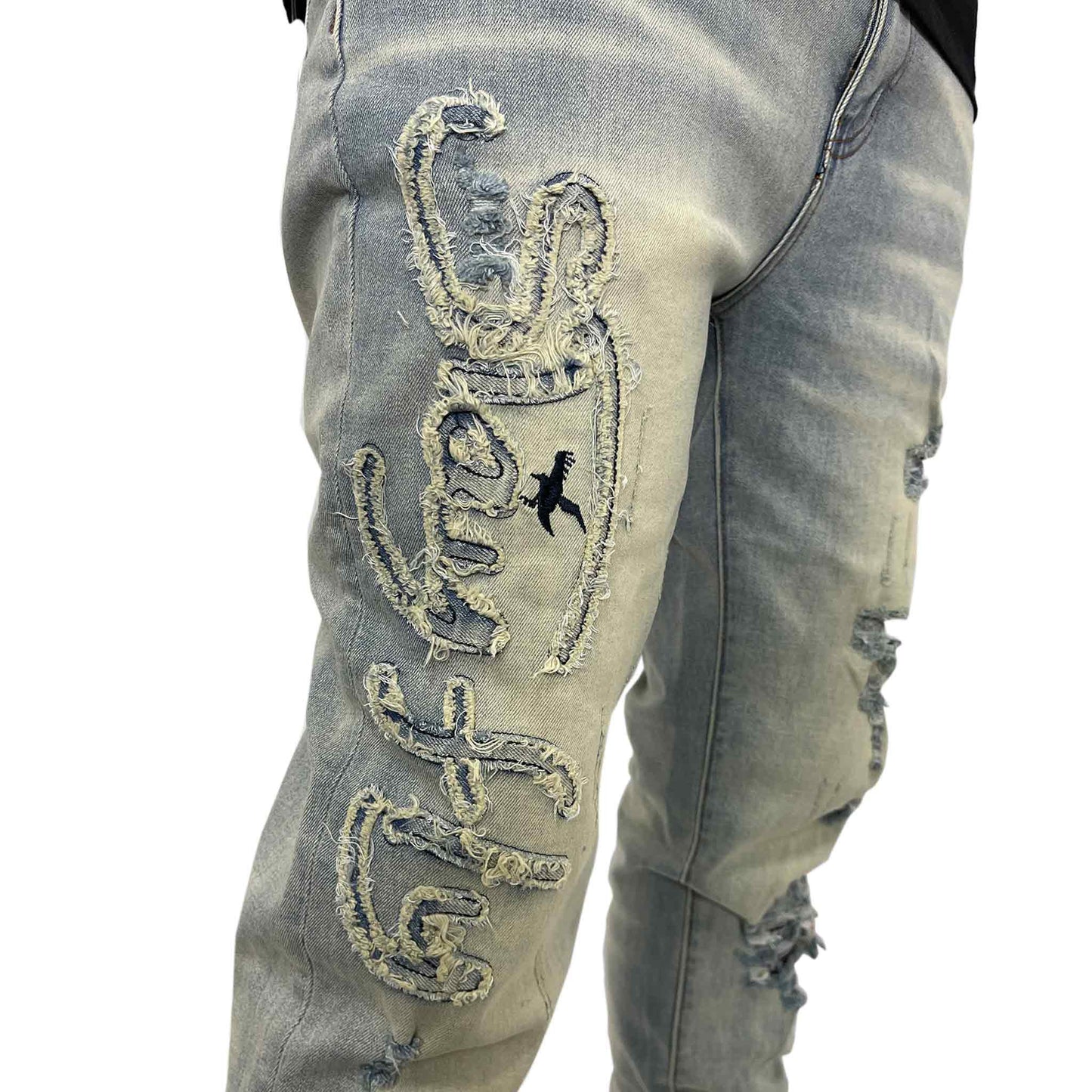 Close up of designed Stay Fly words sewn into right leg of Jean